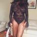 Kavita Flowers, a Chicago escort, posing in a black lace bodysuit.
